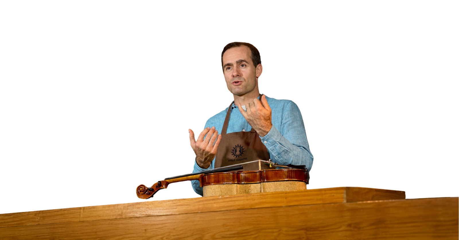Rogério Fagundes explicando o ajuste de um violino na bancada do ateliê